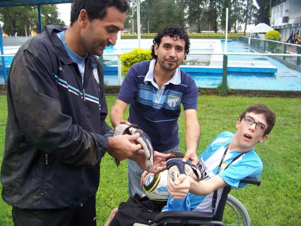 ATAJÓ TODAS. Ischuk le entrega sus guantes a Fede, que también atrapó la pelota. Los regalos van para los tres. GENTILEZA FOTO DE CRISTIAN MAZZOCATTO