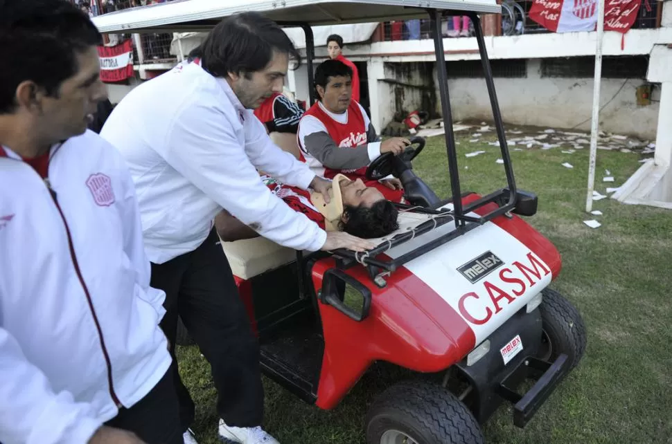 CARAS DE PREOCUPACIÓN. El doctor Roberto Guillén le colocó un cuello ortopédico a Víctor Beraldi para retirarlo del estadio de La Ciudadela. El volante cordobés pasó la noche internado. LA GACETA / FOTO DE JORGE OLMOS SGROSSO
