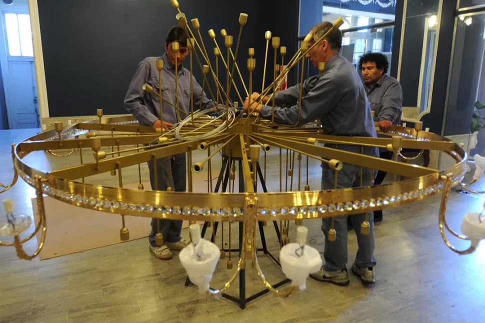 MÍNIMA PARTE. En el foyer del teatro los técnicos hicieron los últimos ajustes sobre el anillo central de la araña. Los hierros con los portalámparas tuvieron que ser doblados para embalarlos en cajones y trasladarlos. LA GACETA / FOTOS DE ANALIA JARAMILLO 