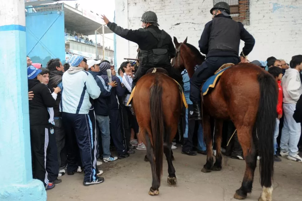 ACORRALADOS. Dos polícias de Caballería arremeten contra los hinchas que hacían filas para ingresar al estadio. LA GACETA / FOTO DE INÉS QUINTEROS ORIO 