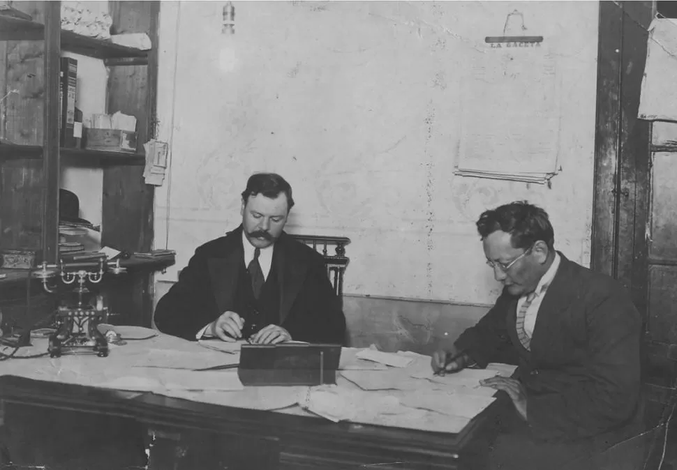 TIEMPOS FUNDACIONALES. Don Alberto García Hamilton y José C. Argañaraz en plena tarea periodística, con lapicera en mano y rodeados de originales en la antigua Redacción de LA GACETA. LA GACETA / ARCHIVO