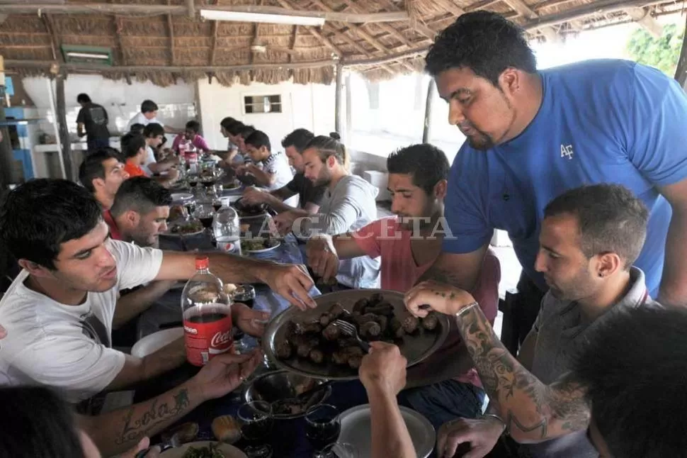 HAY HAMBRE. Calgaro (izquierda) y Peña se anticipan en la repartija de embutidos en uno de los quinchos del complejo de Ojo de Agua. En realidad, la bandeja pasó antes por otra mesa y dejó a este grupo para el último. LA GACETA / FOTOS DE INES QUINTEROS ORIO