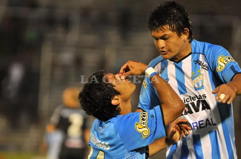 QUE DOLOR. Pulguita intenta asistir a Flecha, que sufrió un codazo de Erramuspe. FOTO DE GABRIEL NAPOLI ESCALERO (ESPECIAL PARA LA GACETA)