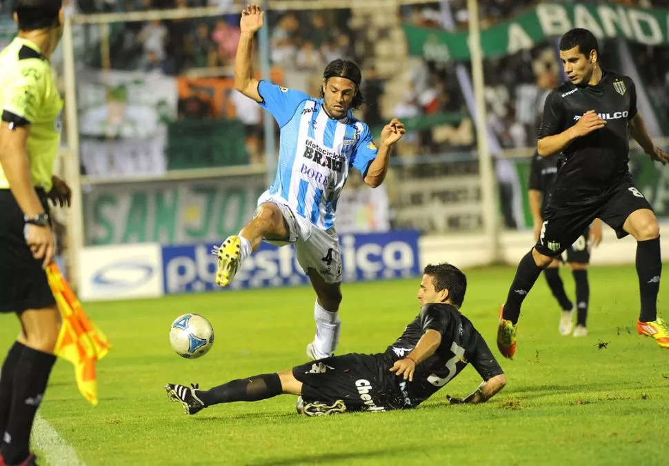 PALOS EN LA RUEDA. LA imagen de Ladino, luchando contra Broggi, bien podría traducirse en las complicaciones que tiene Atlético para sacarse rivales de encima. 