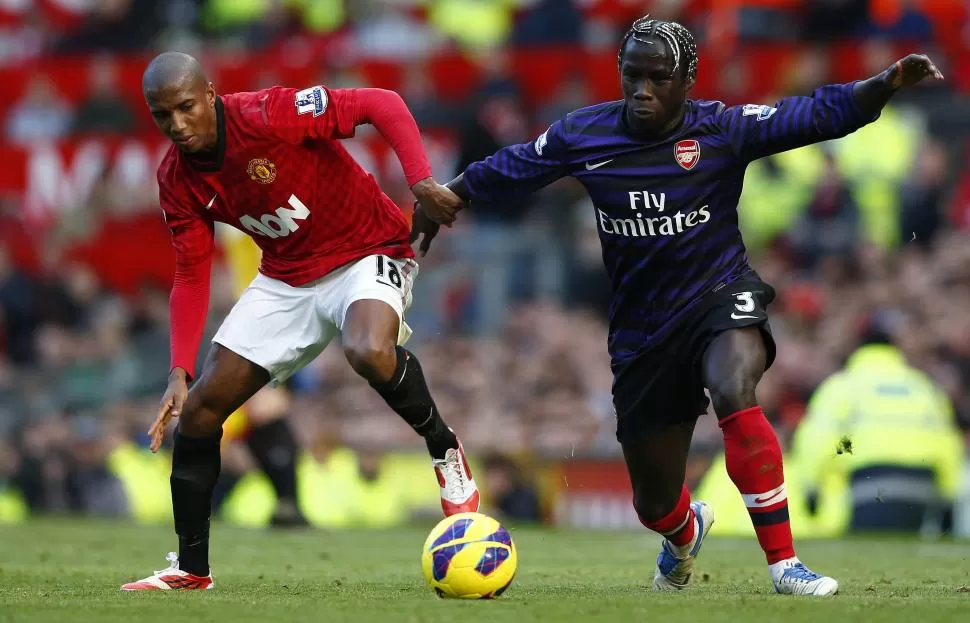 LUCHA. Young, de Manchester pelea cuerpo a cuerpo con Sagna, de Arsenal por la disputa de la pelota. REUTERS