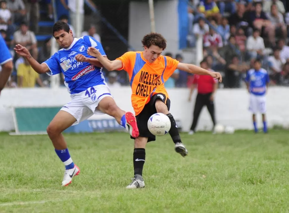 CON LOS TAPONES DE PUNTA. Hernán de Camilo, de Famaillá saca el remate a pesar de la plancha del pié de Carlos Rodríguez. El jugador de Talleres fue amonestado tras esta acción peligrosa. 