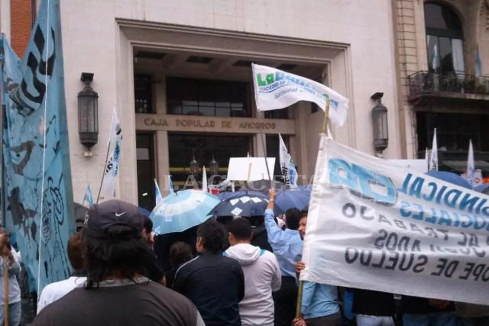 BAJO EL AGUA. La protesta se realizó durante la persistente lluvia de esta mañana. LA GACETA / FOTO DE CARLOS FRIAS  