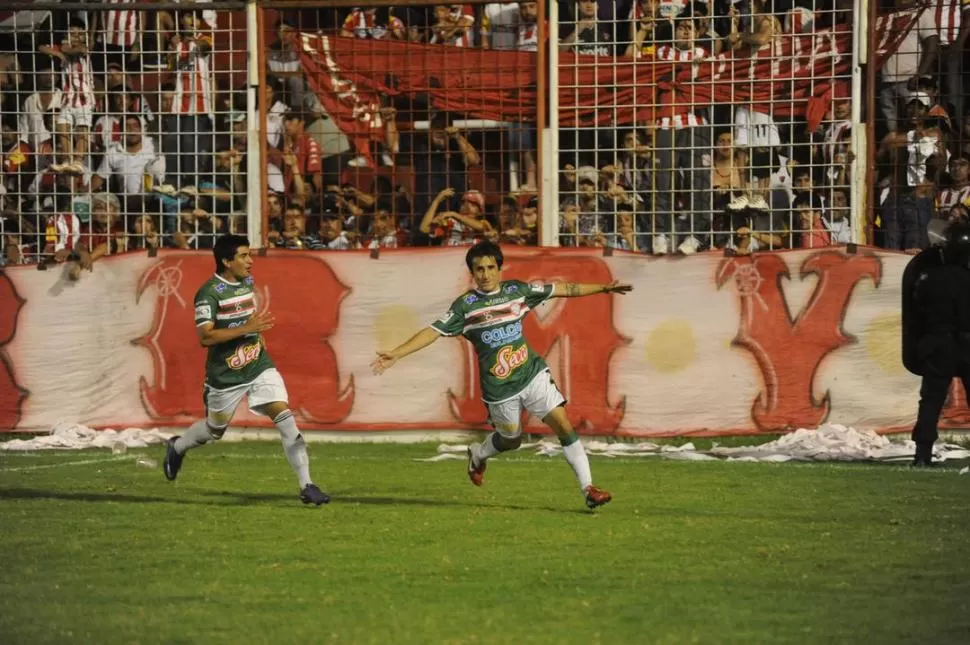 LOCOS DE CONTENTO. Martínez acaba de vencer al arquero Carrera a través de un tiro penal y selló el empate para el expreso verde. Juan Paz corre para unirse al festejo del goleador de San Jorge.  