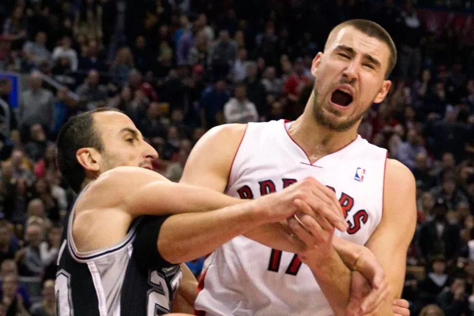 EN TODAS. El argentino le entró duro a Jonas Valanciunas, de los Raptors, durante el juego de anoche en Toronto. REUTERS