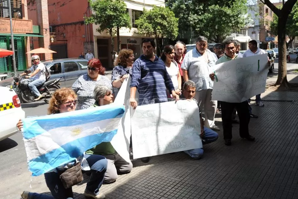 EN LA VEREDA. Familiares y taxistas pidieron, de rodilla, que se autorice el cambio de los modelos para poder trabajar. LA GACETA / FOTO DE FRANCO VERA