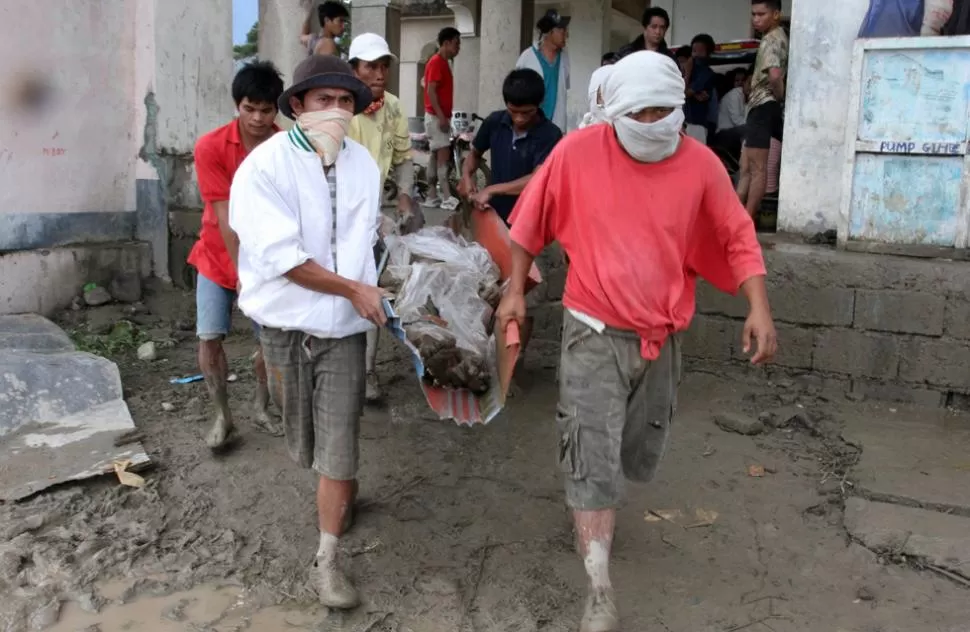 TAREA DURA. El rescate de los cuerpos se dificulta a causa de los aludes de barro. REUTERS