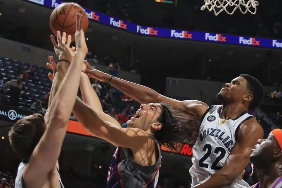 EN LA PINTURA. Scola recibe una falta de Gasol y Gay, durante el juego de anoche en Phoenix. REUTERS