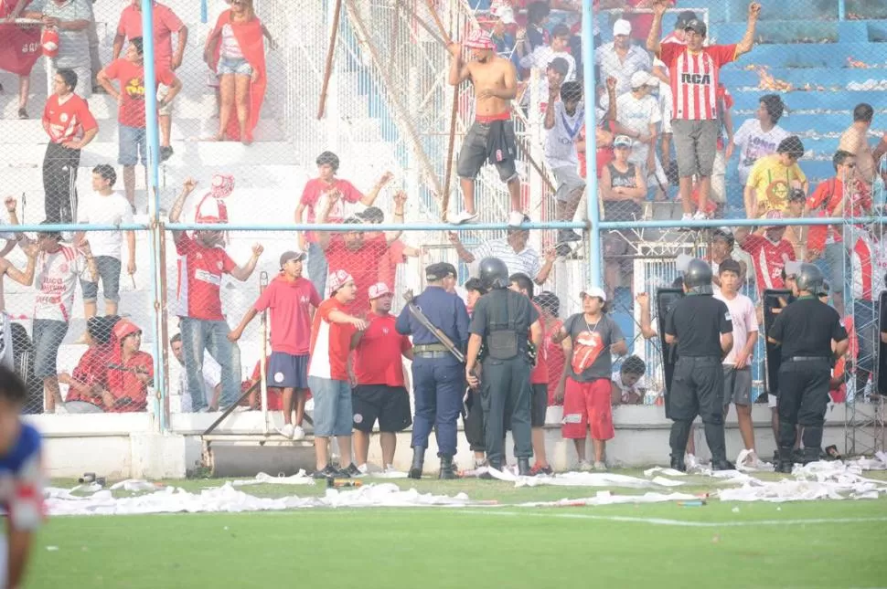 SIN ÉXITO. Los policías hablan con los hinchas antes que invadieran el campo. 