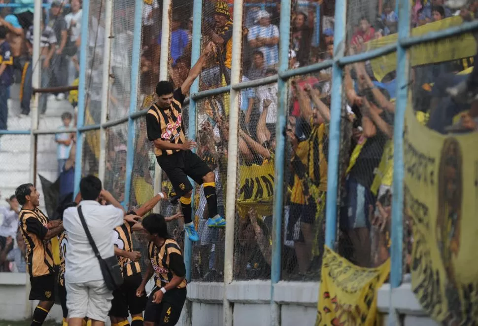 EN LO MÁS ALTO. Sergio Carrizo acaba de convertir el primer gol para Lastenia y lo fue a festejar con su hinchada. 