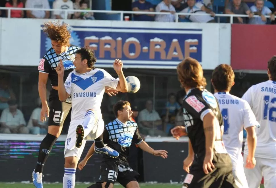 PELEA EN EL AIRE. Ariel Cabral disputa la pelota ante la marcar de Fontanini. 