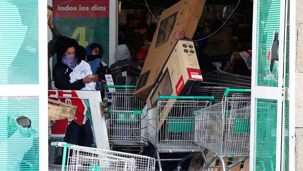 CON LAS MANOS EN LA MASA. Los encapuchados se llevaron LCD (televisores) en los changuitos. REUTERS