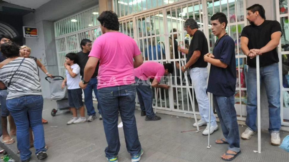 REJAS Y CANDADOS. Personal de algunos comercios salió a custodiar los negocios con palos o fierros. LA GACETA / FOTO DE OSCAR FERRONATO