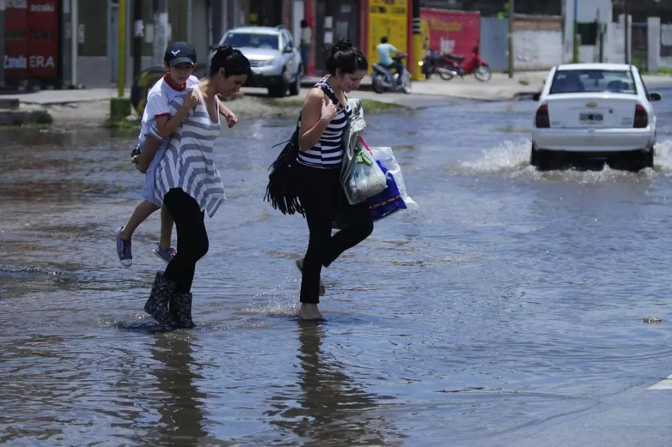 NO QUEDA OTRA. Algunos vecinos se armaron de coraje y atravesaron la calle anegada. Otros se quedaron en sus casas. El ritmo vehicular se detuvo. LA GACETA / FOTOS DE ANALIA JARAMILLO