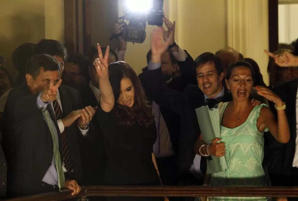 ENTRE GESTOS. Cristina saluda a los grupos partidarios desde un balcón, tras el acto realizado en el salón de las Mujeres Argentinas del Bicentenario. DYN