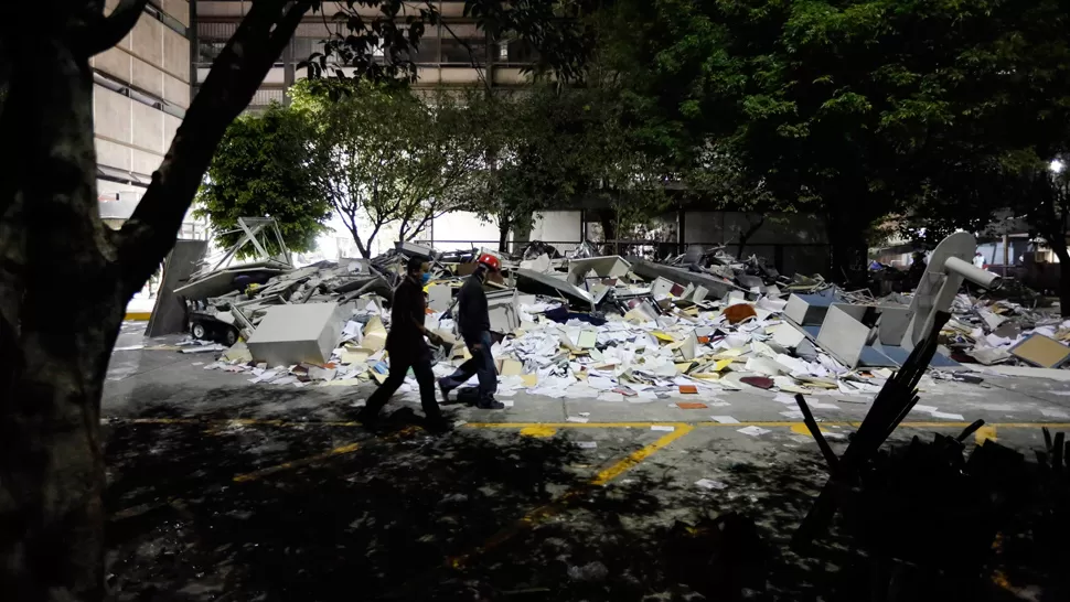 ESCOMBROS. Los equipos de rescate trabajan para auxiliar a las personas atrapadas en el sótano de las oficinas. REUTERS