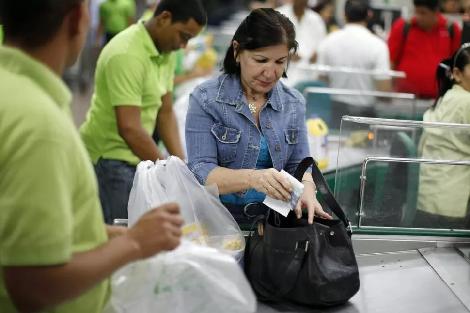 REACCIÓN. Una mujer adquiere alimentos para adelantarse a la medida. REUTERS