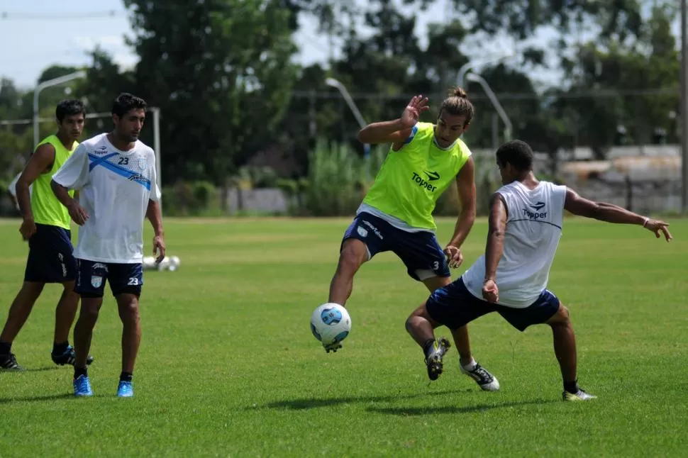 EN ACCIÓN. Cobelli intenta dominar a Tafugo, la nueva pelota de los torneos de Primera y AFA, ante la marca de Montiel y la mirada de Collavini y Calgaro (fondo). 