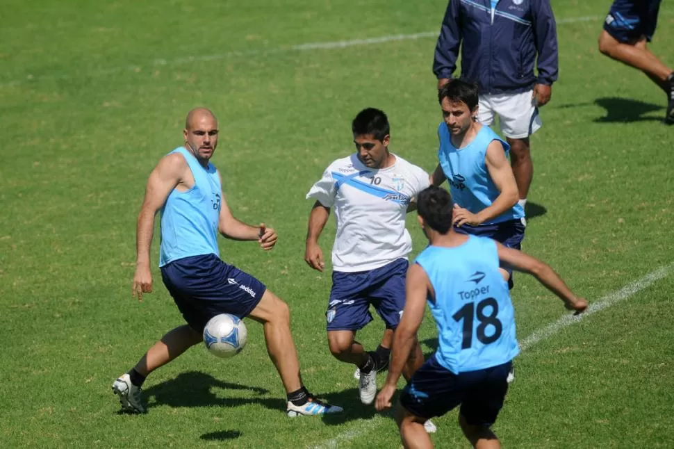 RODEADO. Bustamante intenta pasar entre la marca de Barone y Barrado; el cordobés recuperará la titularidad mañana. LA GACETA / FOTO DE INéS QUINTEROS ORIO (ARCHIVO)