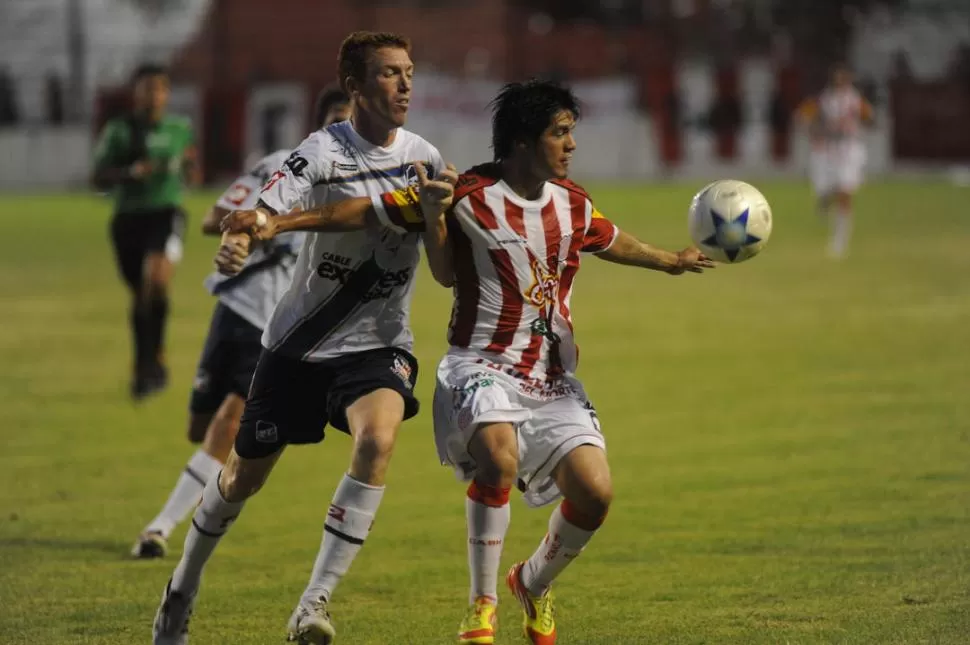 TENÍA LA LLAVE. Roldán protege la pelota ante Zuvinikar; el 10 abrió el duelo con un bombazo tras un rebote que él propició. 