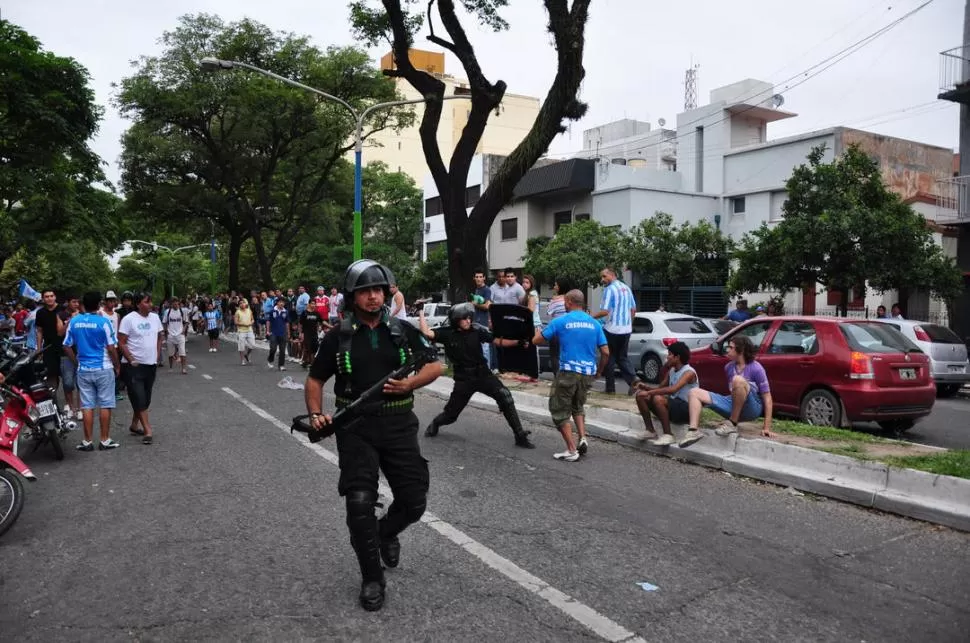 A LA CARGA. Dos policías comienzan a reprimir a los hinchas de Atlético. Según la versión oficial, los incidentes se originaron porque los hinchas no respetaron el orden de la fila. GENTILEZA JOSE DIAZ ROMERO