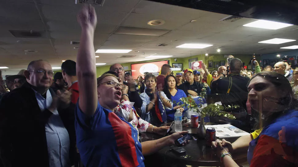 CELEBRAN LA MUERTE. En un restaurante de Miami, los opositores al régimen bolivariano festejaron la noticia. REUTERS