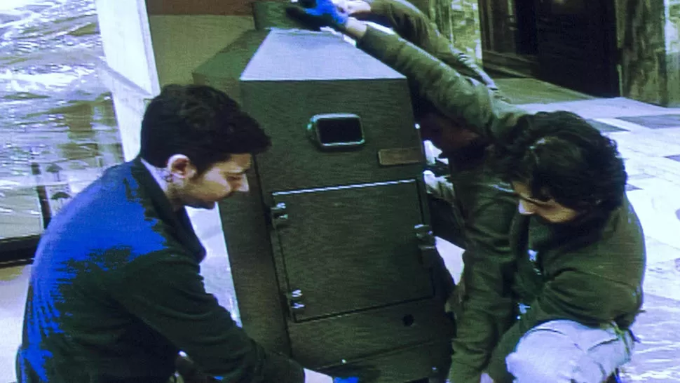 PREPARATIVOS. Personal técnico lleva una de las estufas que se usarán para quemar los votos de los cardenales, en un fotograma rescatado de la transmisión del Vaticano. EFE