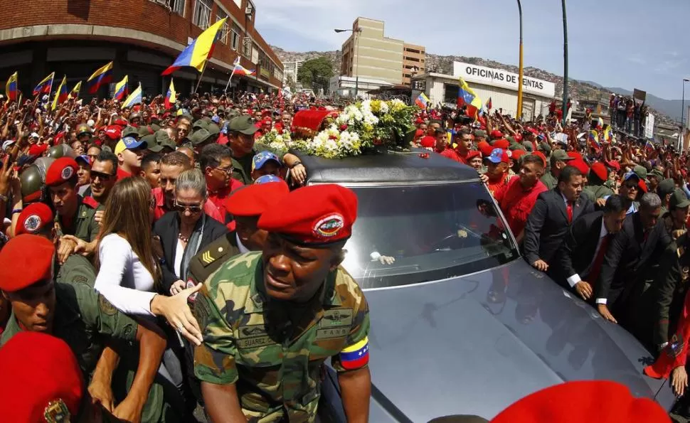 POR LAS CALLES DE CARACAS. El vehículo que lleva el féretro de Chávez avanza a duras penas en medio de una marea humana, desde el Hospital Militar hasta la sede de la Academia Militar. REUTERS