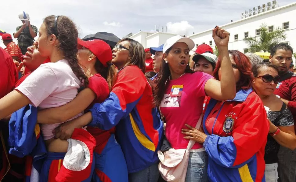 APOYO. Seguidoras del fallecido líder bolivariano se congregaron en la Academia Militar para darle el último adiós. REUTERS