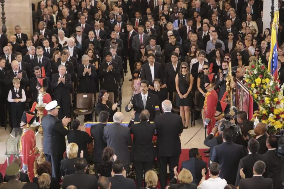 EL ACTO. Maduro coloca el sable de Bolívar sobre el ataúd de Chávez, en uno de los momentos más emotivos.  