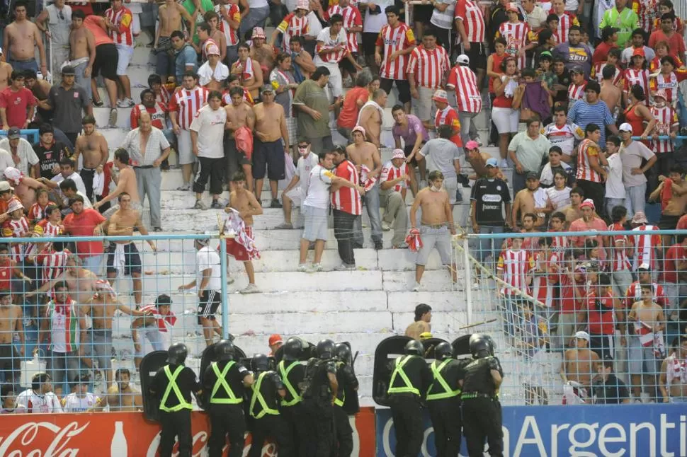 UNA IMAGEN QUE NADIE QUIERE VER EN LA PROVINCIA. Los simpatizantes de San Martín ya rompieron la verja de la tribuna Laprida y los policías forman un cordón para evitar que el público ingrese al campo.  