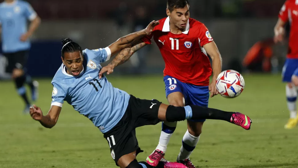 ASPEREZAS. El uruguayo Álvaro Pereira y el chilerno Eduardo Vargas disputan la pelota, en un partido que fue favorable para los trasandinos. 