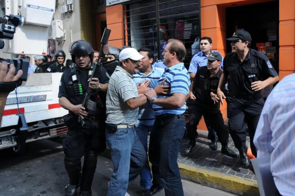 FORCEJEOS Y CORRIDAS. Docenas de agentes de Infantería intentaron distanciar a Cortalezzi de donde estaban los manifestantes de La Bancaria. LA GACETA / FOTOS DE INéS QUINTEROS ORIO