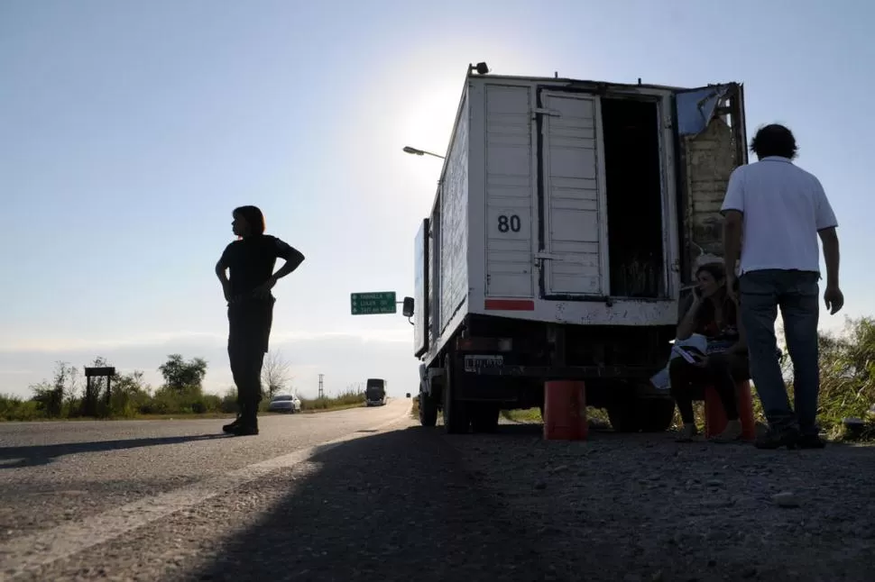 EN LA BANQUINA. Una policía custodia el camión que fue asaltado el sábado al costado de la 323, cuando las víctimas no conseguían que los auxilien. LA GACETA / FOTO DE DIEGO ARAOZ