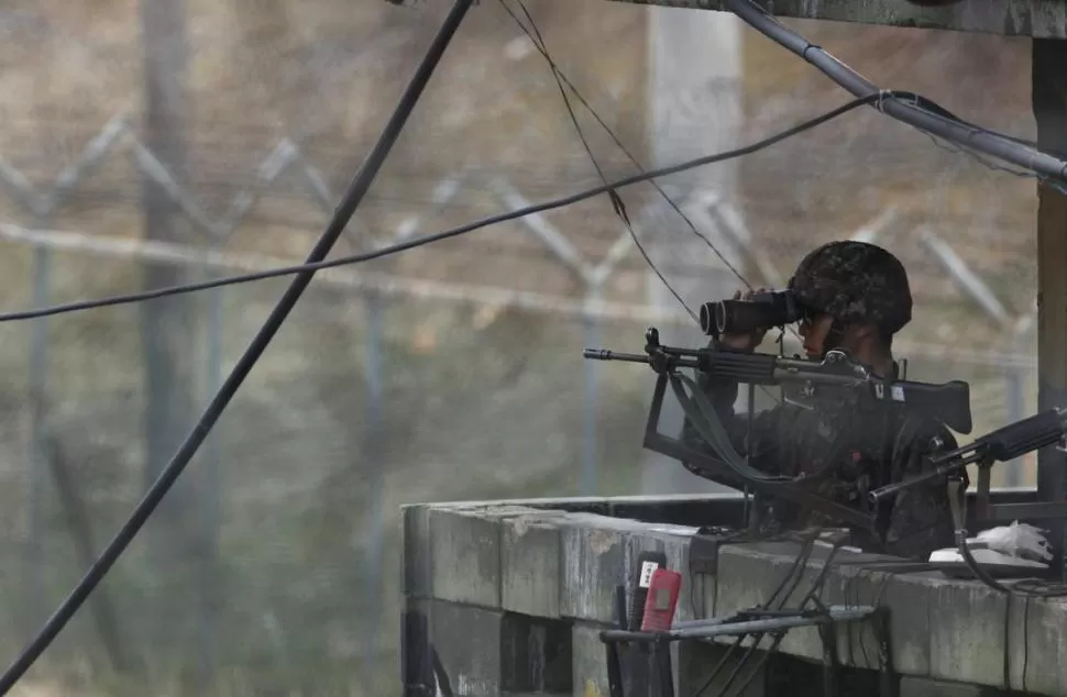 EN LA FRONTERA. Un soldado surcoreano escudriña el horizonte con sus binoculares, en la zona de Paju, al norte de Seúl, la capital del país. REUTERS