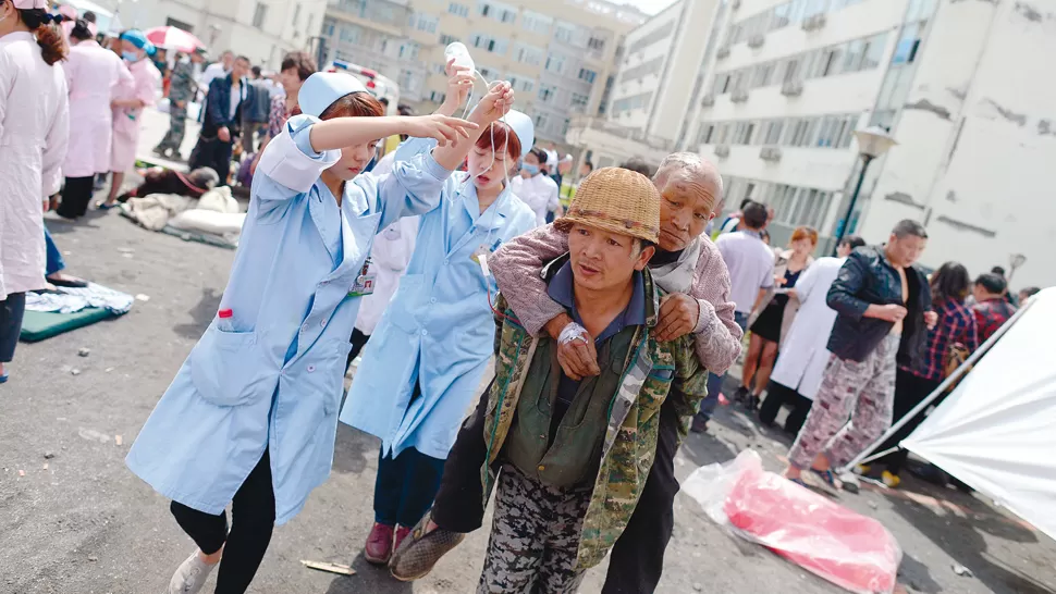 EN EMERGENCIA. La atención médica a los heridos se realiza en plena calle. REUTERS