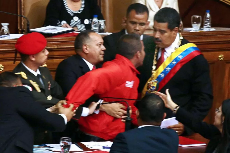 MOMENTO DE NERVIOSISMO: Un individuo interrumpió el discurso de Maduro y quiso hablar con él. Fue reducido por la custodia y retirado del lugar. FOTOS DE TELAM