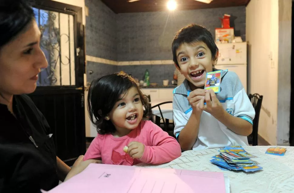 SOY EL REY.... Martiniano muestra las cartas que ganó en la tapadita, ante la risa inocente de su hermana Lourdes y la mirada de su mamá. LA GACETA / FOTOS DE HECTOR PERALTA 