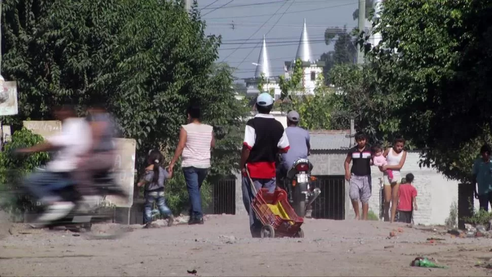 BAJO EL SOL. La calle de tierra es el territorio en el que se mueven los vecinos que salen a trabajar para sortear las dificultades económicas.  