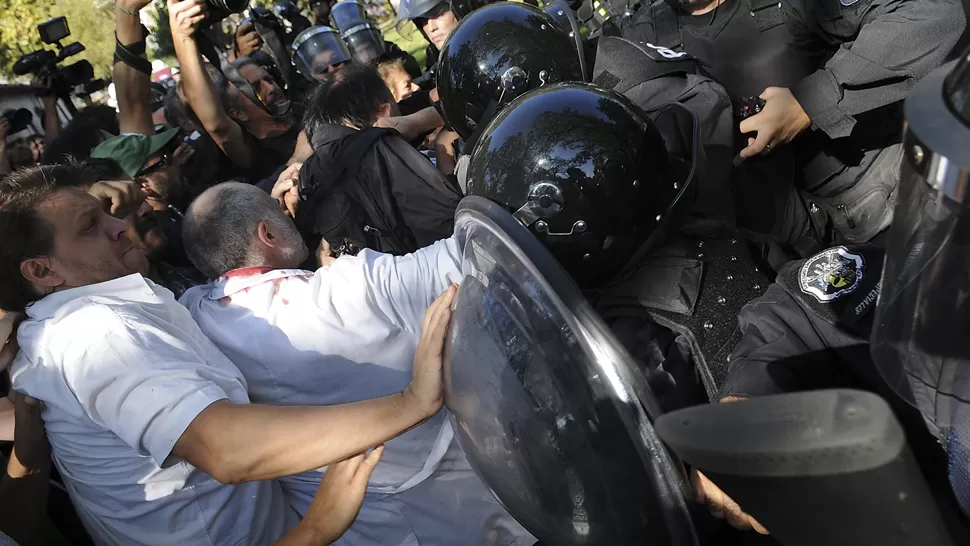 A GOLPES. Un grupo de empleados del Borda intentó defender el taller de la demolición y la Policía respondió con golpes y gases. TELAM