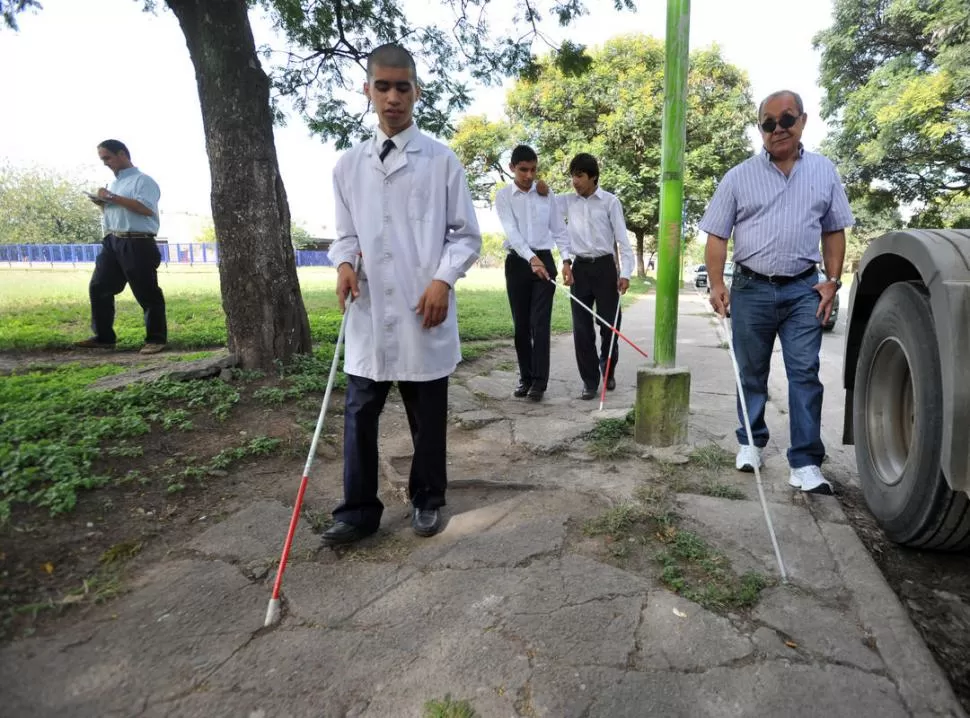 PASO A PASO. Roger, Ezequiel y Alan caminan por la Buenos Aires y esquivan un poste de luz; con ellos, el profesor Gasparic. LA GACETA / FOTO DE DIEGO ARAOZ