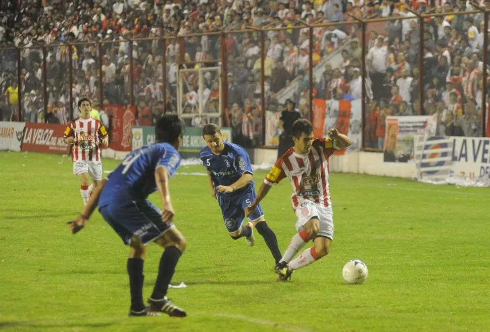 ALOCADA CARRERA. Juan Chanquía intenta llevarse la pelota ante la dura y pegajosa marca de Franco Amaya. 