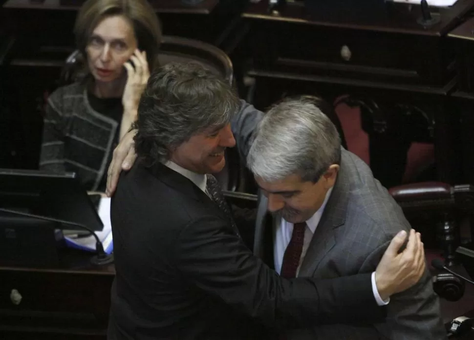 LA EUFORIA, AL FINAL. Amado Boudou abraza a Aníbal Fernández. Atrás, Beatriz Rojkés atiende una llamada. DYN