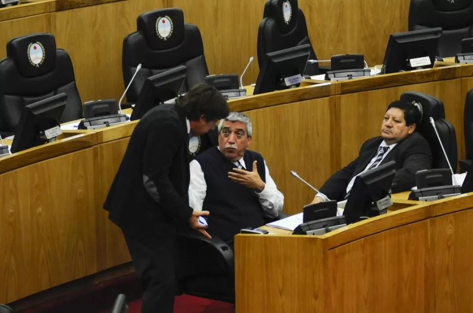 DOS POSTURAS. Bussi (FR), de pie, habla con Álvarez (PJ) durante la sesión. El peronista Orellana los observa. PRENSA LEGISLATURA / CARLOS VILLAGRA