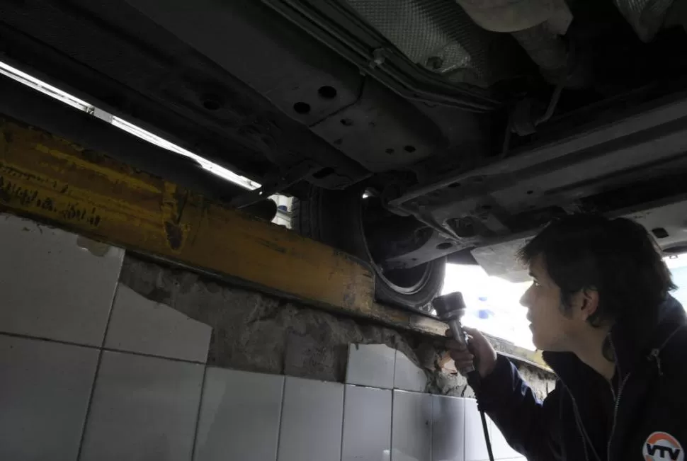 EN LA FOSA. Un técnico revisa el tren delantero de un vehículo en un taller; los daños más habituales suelen detectarse en este componente. LA GACETA / FOTO DE JORGE OLMOS SGROSSO 