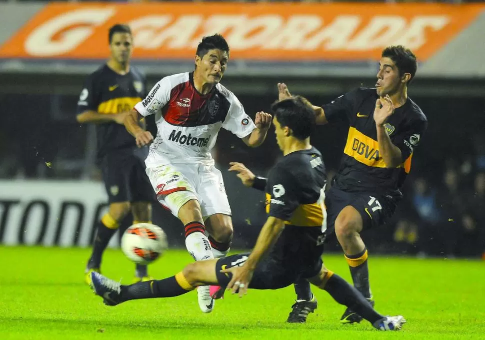 A TODO O NADA. Matías Caruzzo y Cristian Erbes, de los xeneizes, llegan al cruce antes que Milton Casco, de la lepra. El cotejo prometía muchas emociones, pero al final hubo pocas. 